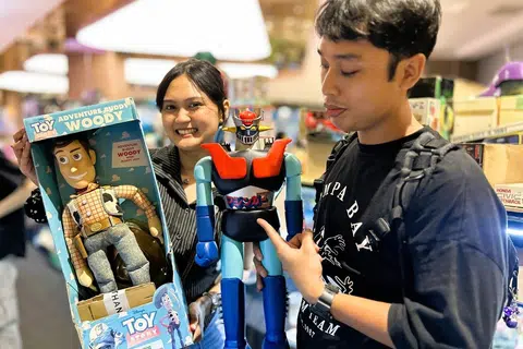 Encik Amsyar Khalid Amat Samsuri (kanan), bersama isterinya, Cik Farzana Iman Abdul Razak, memegang permainan animasi Jepun, Mazinger Z dan animasi Amerika Syarikat, Toy Story.