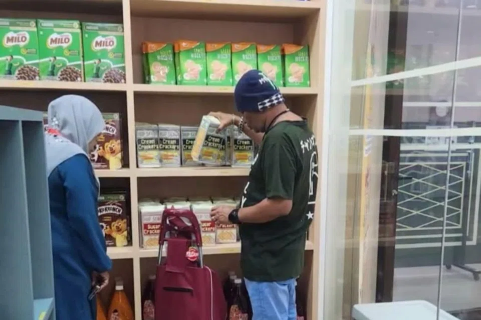 Sukarelawan Eksekutif Muslimah di Masjid Hasanah (kiri) membantu penerima manfaat di Komuniti Pantri@Hasanah. 