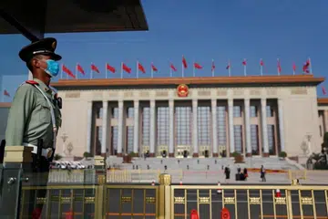 SIAP SEDIA: Seorang anggota polis paratentera berkawal di diluar Dewan Besar Rakyat sebelum sesi pembukaan Kongres Kebangsaan Rakyat China semalam. 