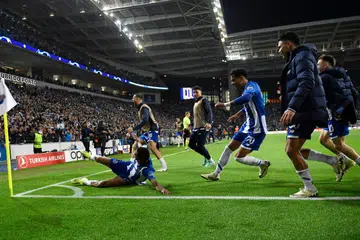 Pemain sayap FC Porto, Galeno (terbaring), meraikan jaringan kemenangannya bersama rakan sepasukan selepas mengalahkan Arsenal 1-0 semasa perlawanan pertama pusingan 16 terakhir Liga Juara-Juara di Stadium Estadio do Dragao, Porto.