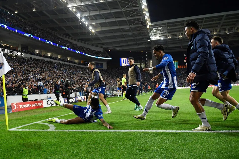 Pemain sayap FC Porto, Galeno (terbaring), meraikan jaringan kemenangannya bersama rakan sepasukan selepas mengalahkan Arsenal 1-0 semasa perlawanan pertama pusingan 16 terakhir Liga Juara-Juara di Stadium Estadio do Dragao, Porto.