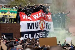 LAKUKAN BANTAHAN: (Gambar atas) Penyokong melakukan protes terhadap pemilik Manchester United di luar dan dalam Stadium Old Trafford dekat Manchester. - Foto REUTERS