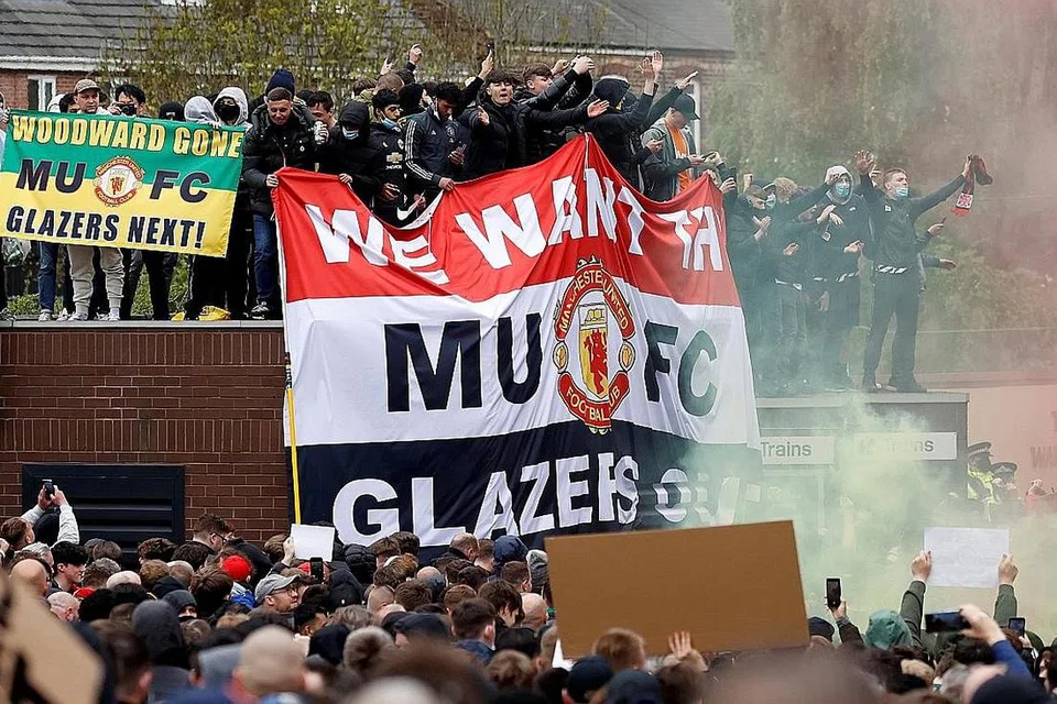 LAKUKAN BANTAHAN: (Gambar atas) Penyokong melakukan protes terhadap pemilik Manchester United di luar dan dalam Stadium Old Trafford dekat Manchester. - Foto REUTERS