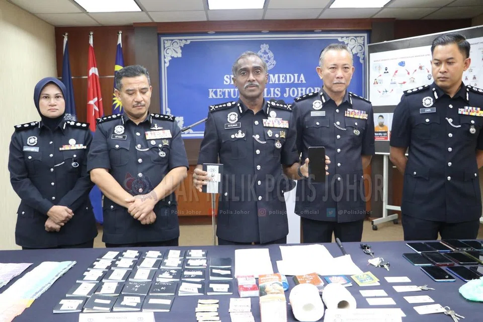 Ketua Polis Johor, Pesuruhjaya M. Kumar (tengah), menunjukkan barangan yang dirampas daripada sindiket pelacuran ‘Geng Bala’, seperti wang tunai, pasport, kondom dan telefon bimbit.