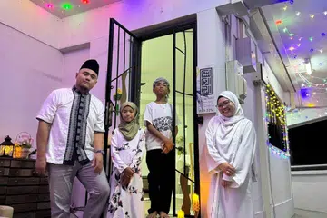 Keluarga Cik Irhana La Asis, 30 tahun (kanan)  bergambar dengan hiasan lampu lap-lip mereka bersama suami, Encik Syahril Omar Taib, 35 tahun (kiri), dan anak-anak mereka, Nurullah, 10 tahun; dan Said Muhd, 11 tahun.