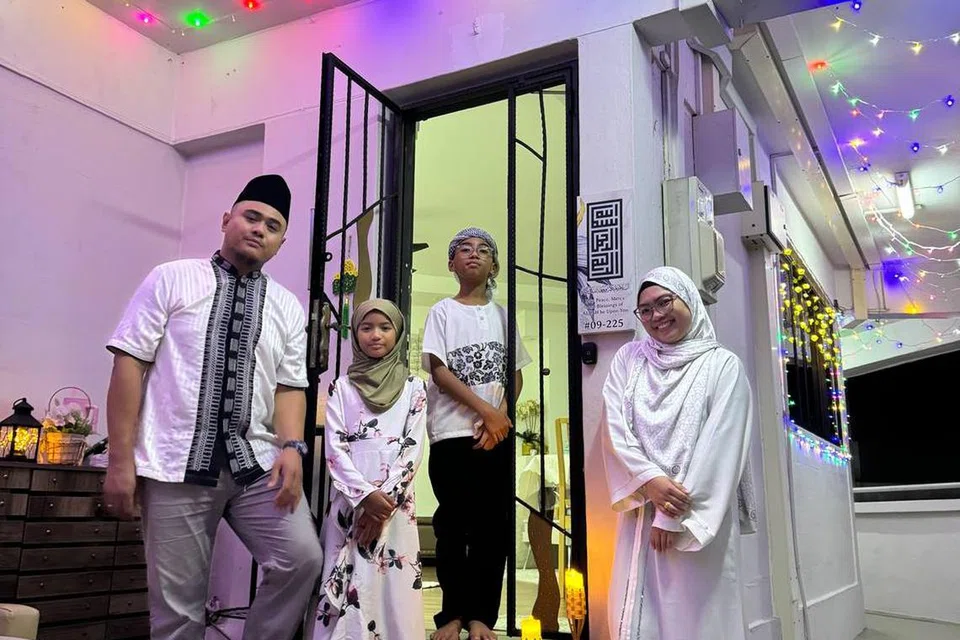 Keluarga Cik Irhana La Asis, 30 tahun (kanan)  bergambar dengan hiasan lampu lap-lip mereka bersama suami, Encik Syahril Omar Taib, 35 tahun (kiri), dan anak-anak mereka, Nurullah, 10 tahun; dan Said Muhd, 11 tahun.