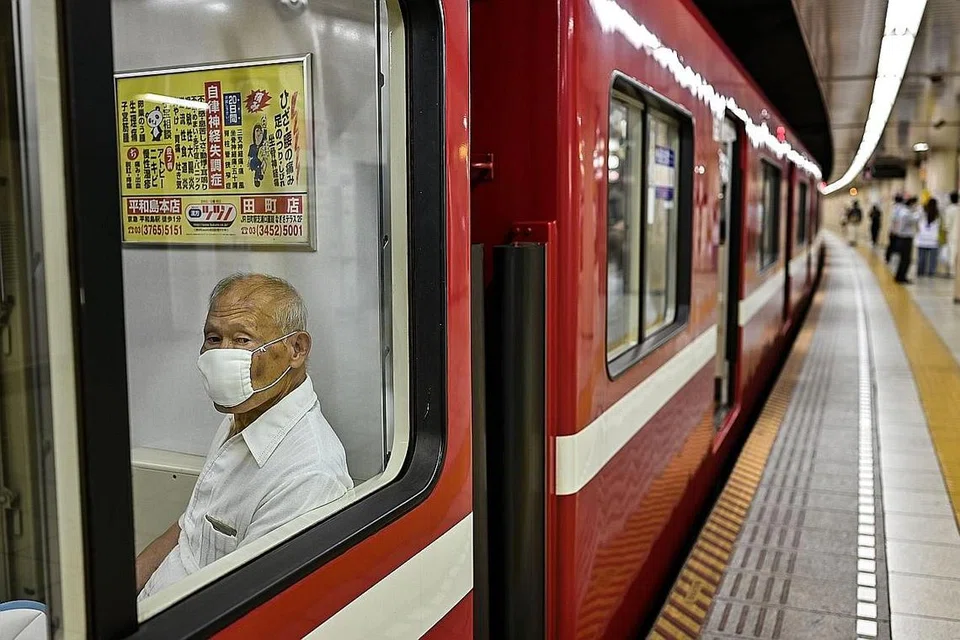 JAGA KESIHATAN DIRI: Pengguna pengangkutan awam di Jepun mengenakan pelitup semasa menaiki kereta api sedang Tokyo melaporkan 59 kes baharu koronavirus di ibu kota negara itu semalam. - Foto AFP