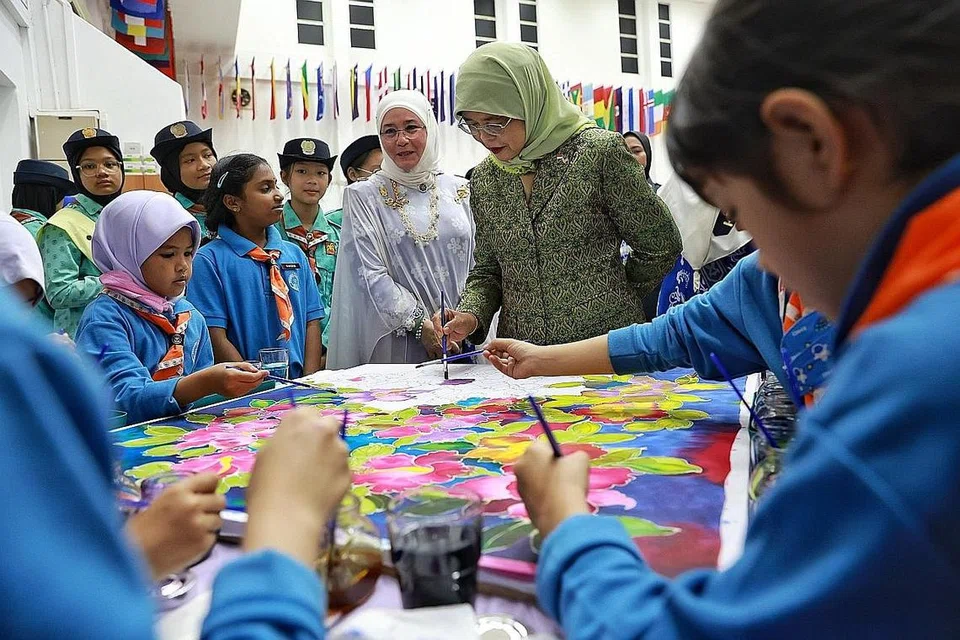 LAWAT PANDU PUTERI: Presiden Halimah Yacob (kanan), yang ditemani Raja Permaisuri Agong Tunku Azizah Aminah Maimunah Iskandariah, menyertai melukis batik di Wisma Pandu Puteri. - Foto ST