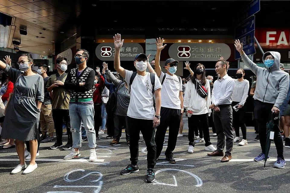 BANTAHAN: Penunjuk perasan mengangkat tangan sedang mereka menghadiri bantahan di kawasan Central. - Foto Reuters.