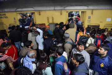 Penumpang, kebanyakannya yang hendak pergi ke festival Kumbh Mela, berebut-rebut untuk menaiki kereta api di Stesen Kereta Api New Delhi di New Delhi, India pada 15 Februari.