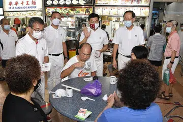 TEMU PENDUDUK: Calon pasukan PAP di GRC Marine Parade (dari kiri), Encik Edwin Tong, Encik Mohd Fahmi Aliman; Encik Tan Chuan-Jin dan Dr Tan See Leng menemui penduduk di 50A Pasar Marine Terrace kelmarin. Encik Seah Kian Peng tiada dalam kunjungan itu. - Foto BH oleh DESMOND WEE