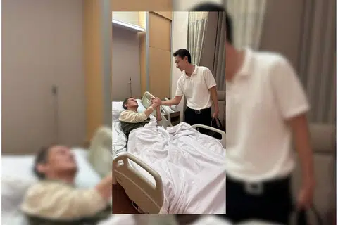 DIRAWAT DI HOSPITAL: Encik Peter Vendel (sedang berbaring), diziarah seorang teman di sebuah bilik wad di Hospital Mount Elizabeth, Novena.