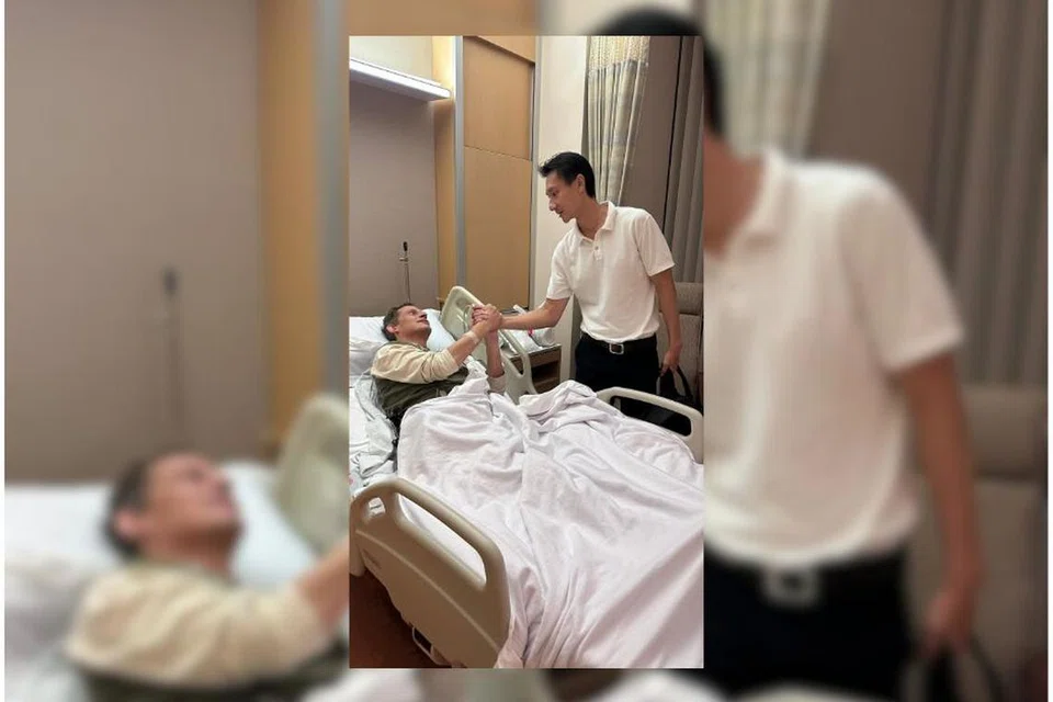 DIRAWAT DI HOSPITAL: Encik Peter Vendel (sedang berbaring), diziarah seorang teman di sebuah bilik wad di Hospital Mount Elizabeth, Novena.