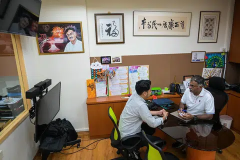 Bakal calon PAP untuk GRC Jurong East-Bukit Batok, Encik Murali Pillai (kanan) sedang menunjukkan buku nota kecilnya kepada wartawan Berita Harian (BH), Encik Muhammad Hazman Abd Aziz. 