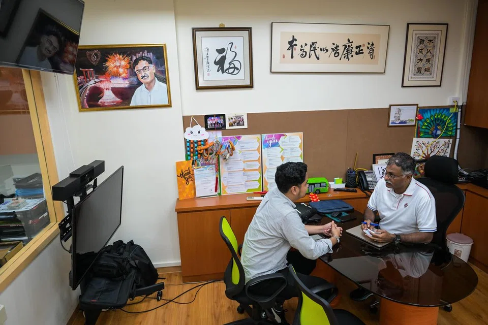 Bakal calon PAP untuk GRC Jurong East-Bukit Batok, Encik Murali Pillai (kanan) sedang menunjukkan buku nota kecilnya kepada wartawan Berita Harian (BH), Encik Muhammad Hazman Abd Aziz. 