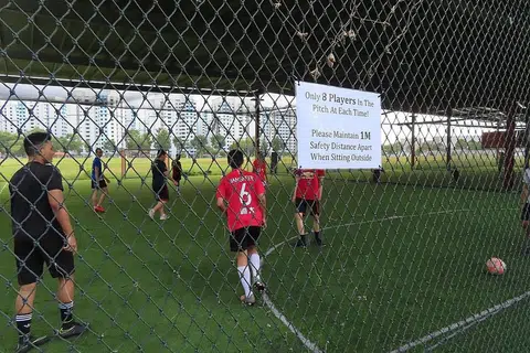 LEBIH MERIAH MAIN BOLA: Kumpulan seramai lapan pemain bermain bola sepak di gelanggang futsal Golazo Futsal Singapore semalam setelah Singapura melangkah ke fasa ketiga pembukaan semula negara. - Foto BH oleh ZULAIQAH ABDUL RAHIM