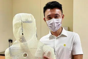 JALANI RAWATAN: Encik Baey Yam Keng menyiarkan gambar beliau bersama pelindung yang digunakan semasa menjalani terapi radiasi. - Foto FACEBOOK BAEY YAM KENG