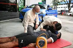 UPAYA RESPONS DENGAN CEPAT: Pemandu teksi Comfort DelGro, Encik Irmansah Azir (kanan) dan Cik Foo Mui Leng, yang telah menjalani latihan Program Kesediaan Kecemasan Masyarakat (CEPP) oleh SCDF, melakonkan prosedur bantuan kecemasan bagi menyedarkan semula seorang 'mangsa' serangan jantung. - Foto BH oleh KUA CHEE SIONG