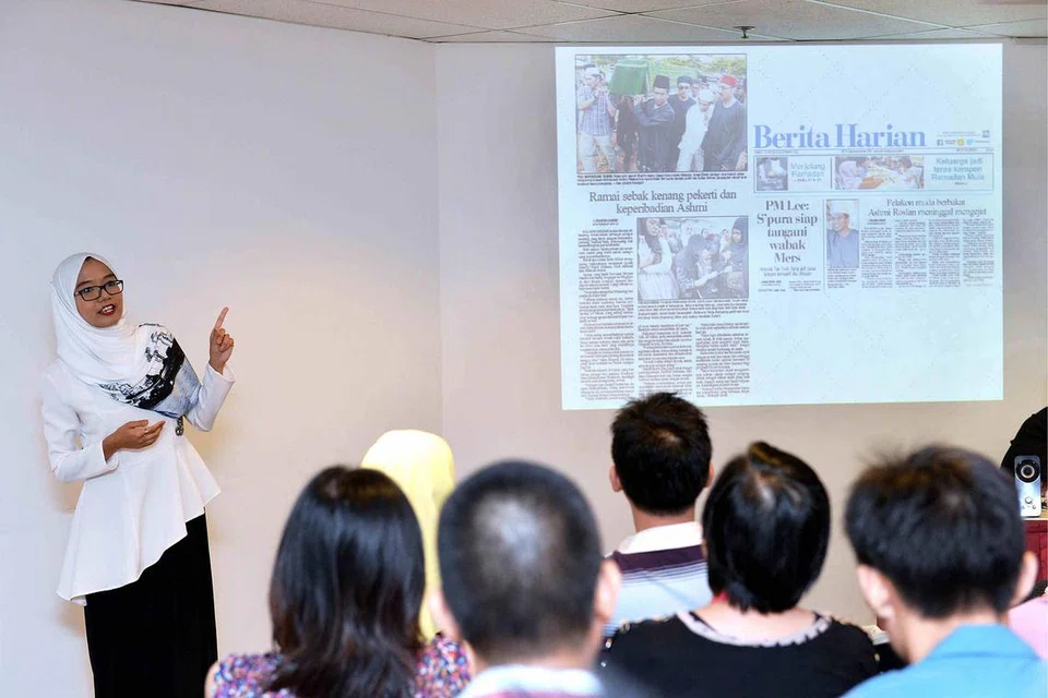KONGSI PENGALAMAN: Wartawan BH, Cik Shahida Sarhid (kiri), menjelaskan kepada peserta tentang kategori berita yang berbeza sempena Jejak Pembelajaran guru di Singapore Press Holdings semalam. - Foto M.O. SALLEH