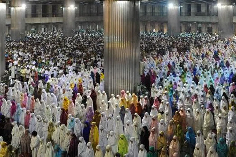 TARAWIH PERTAMA: Kaum wanita penduduk Jakarta tidak ketinggalan menyambut kedatangan Ramadan Ahad lalu dengan menunaikan solat sunat tarawih di Masjid Al-Istiqlal pada malam sebelumnya. - Foto-foto AFP dan REUTERS.