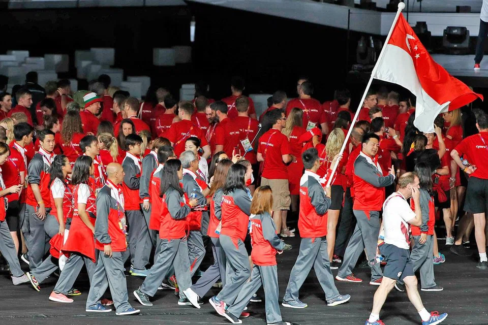 MERIAHKAN ACARA: Pemain muda badminton, Kean Yew Loh, membawa bendera negara semasa berbaris dengan rakan-rakannya yang lain di acara penutup Sukan Komanwel ini dalam satu majlis penuh gah dan berwarna-warni di Stadium Carrara, Gold Coast, malam tadi. - Foto REUTERS