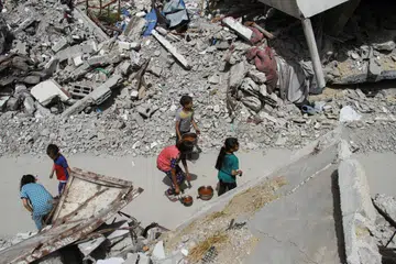 Kanak-kanak Palestin berjalan pulang selepas menerima bantuan makanan di Jabalia, utara Gaza, yang menjadi sasaran pengeboman tentera Israel buat hari kedua pada 24 April.
