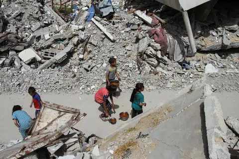 Kanak-kanak Palestin berjalan pulang selepas menerima bantuan makanan di Jabalia, utara Gaza, yang menjadi sasaran pengeboman tentera Israel buat hari kedua pada 24 April.