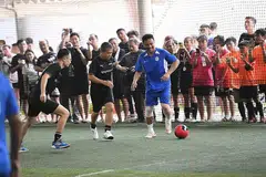 TUNJUK KEBOLEHAN: Encik Edwin Tong (tengah) dan Fandi Ahmad (kanan) beraksi untuk mengumpul $111,000 dalam acara Futsal Amal Singapore Exchange Bull Charge. - Foto SGX