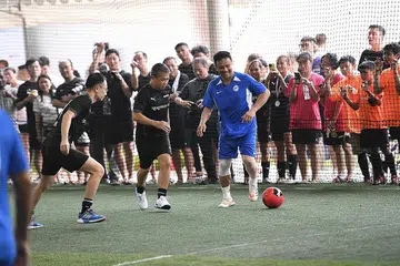 TUNJUK KEBOLEHAN: Encik Edwin Tong (tengah) dan Fandi Ahmad (kanan) beraksi untuk mengumpul $111,000 dalam acara Futsal Amal Singapore Exchange Bull Charge. - Foto SGX