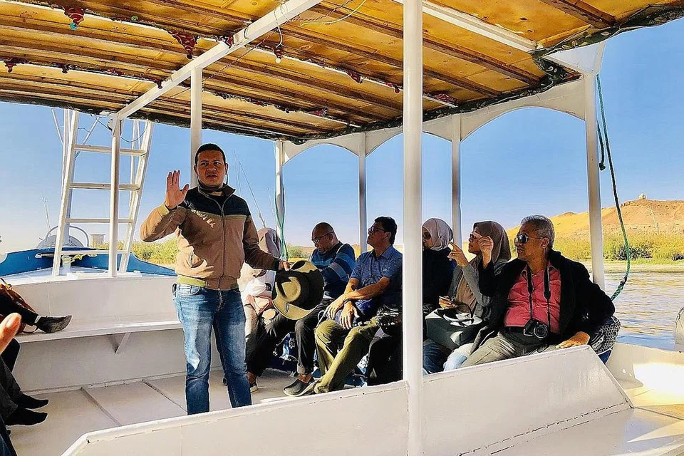 BENTANG KISAH SUNGAI NIL: Pemandu pelancong, Encik Islam Abdelati (berdiri), sedang memberi penjelasan tentang Sungai Nil dan penduduk Perkampungan Nubian sambil rombongan pelancong Azza Travel & Tours menikmati angin sepoi-sepoi bahasa yang menenangkan. - Foto BH oleh HARYANI ISMAIL