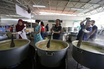 LAKU KEBAIKAN: Relawan bantu masak bubur bagi orang awam di Masjid Khalid.
