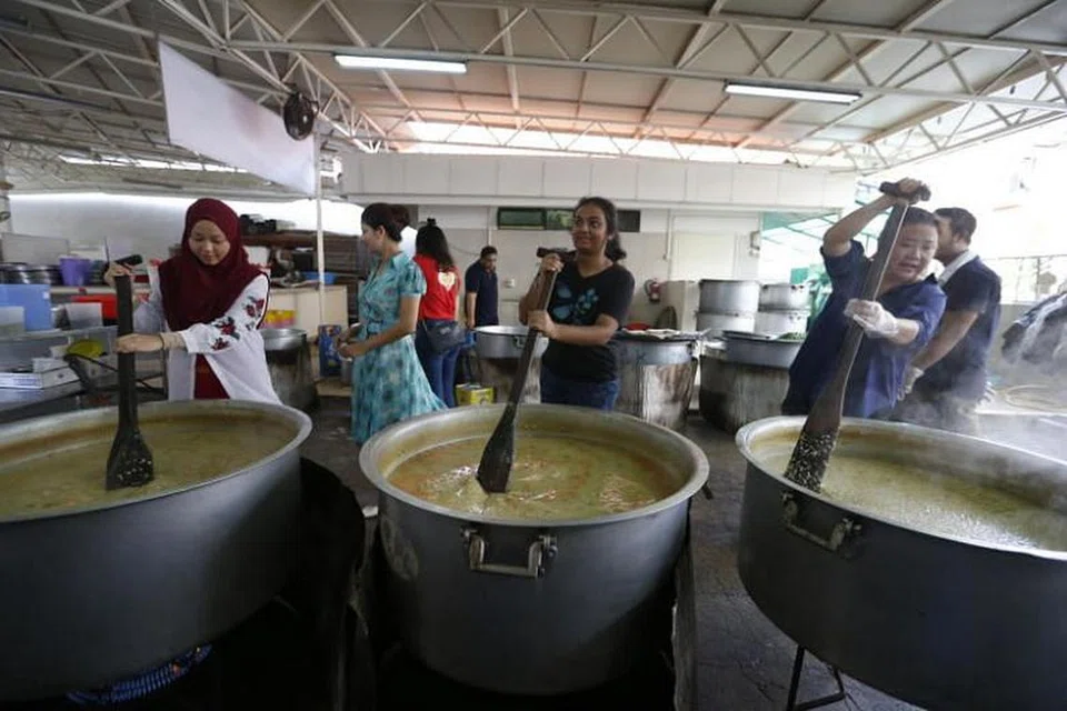 LAKU KEBAIKAN: Relawan bantu masak bubur bagi orang awam di Masjid Khalid.