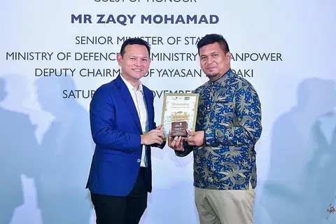 SUMBANGAN TUTOR DIIKTIRAF: Menteri Negara Kanan (Pertahanan merangkap Tenaga Manusia), Encik Zaqy Mohamad menyampaikan Anugerah Sumbangan Terbaik kepada salah seorang penerima, pendidik dan tutor MTS sepanjang sembilan tahun, Encik Muhammad Jailani Abu Talib ketika acara penyampaian Anugerah Tutor Mendaki di HomeTeamNS Khatib. - Foto MENDAKI