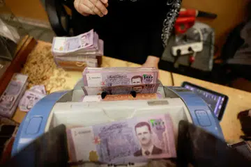 Kakitangan dari Bank Pusat Syria di Damsyik sedang menjalankan tugas selepas Presiden Bashar al-Assad digulingkan.