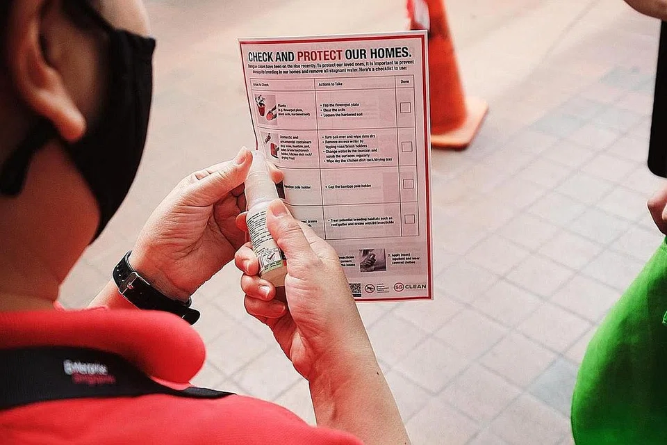 AGIH UBAT CEGAH NYAMUK: NEA berkerjasama dengan MOE mengagih ubat penghalau nyamuk kepada pelajar sekolah dalam kawasan kelompok denggi terbesar. - Foto NEA