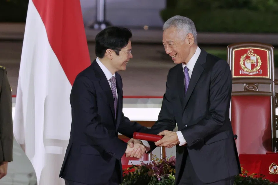 Perdana Menteri, Encik Lawrence Wong, bersalaman dengan Menteri Kanan, Encik Lee Hsien Loong.