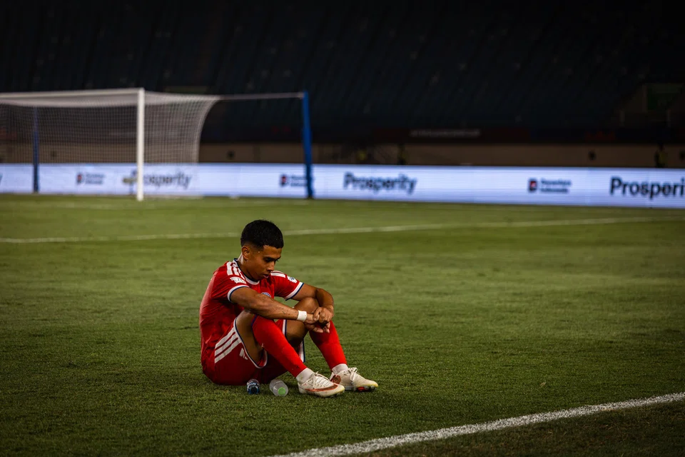 Pemain sayap Singa, Farhan Zulkifli, terduduk kecewa selepas skuad kebangsaan tewas 0-6 kepada Malaysia sekali gus tersingkir daripada kejohanan. Ketumpulan jentera serangan menjadi cabaran utama skuad Singa menjelang Piala Asia, kurang empat bulan pada Januari 2027.