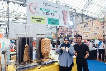 BERI NILAI LEBIH BAIK: Cik Nur Azlina Azlan bersama salah seorang pekerjanya, tahun ini menawarkan kelainan dengan menawarkan kebab rendang. - Foto BM oleh IQBAL FAIZAL