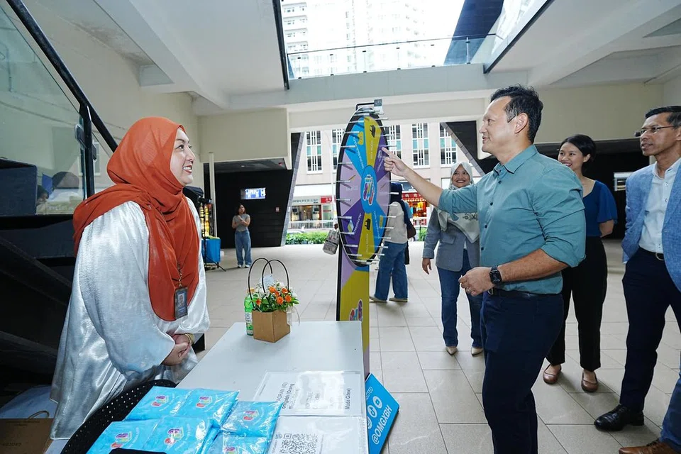 Menteri Negara Kanan (Pertahanan merangkap Tenaga Manusia), Encik Zaqy Mohamad (kanan), mencuba permainan di salah satu reruai dalam Pesta Pelancaran OMGxBH.