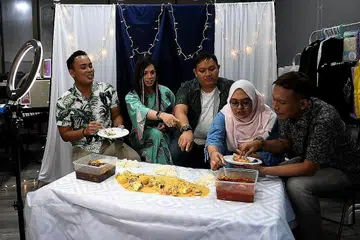 GOTONG-ROYONG TINJAU KESAN COVID-19: Peneraju 'MakMok Show', (dari kiri) Encik Heder Johari, Cik Sasya Foxx, Encik Zahid Ali, Cik Nur Zainab M Barkhia dan Encik Razalee Rais antara lain membantu mempromosikan perniagaan makanan dan minuman serta peniaga dari rumah yang terjejas oleh pandemik Covid-19. Foto ini dirakam ketika mereka mengulas sajian makanan laut 'Our ShellOut Platter' di City Plaza. Lima rakan mereka dalam pasukan MakMok tiada dalam foto. - Foto BH oleh KHALID BABA