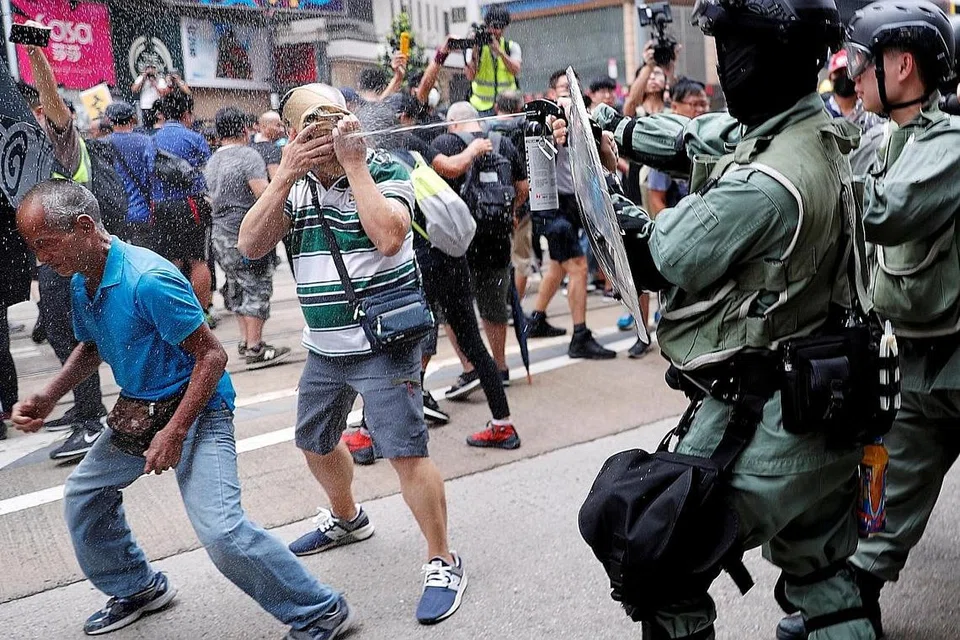 BANTAHAN: Polis pencegah rusuhan menyembur cecair lada ke arah penunjuk perasaan di Causeway Bay, Hong Kong, baru-baru ini. - Foto Reuters