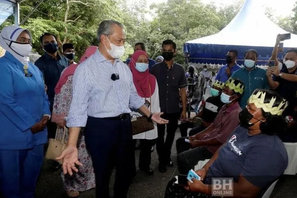 TINJAU VAKSINASI ORANG ASLI: Perdana Menteri Malaysia, Tan Sri Muhyiddin Yassin beramah mesra bersama penerima vaksin daripada golongan Orang Asli ketika meninjau PPV Dewan Serbaguna Pagoh, Muar, Johor. - Foto NSTP/ NUR AISYAH MAZALAN