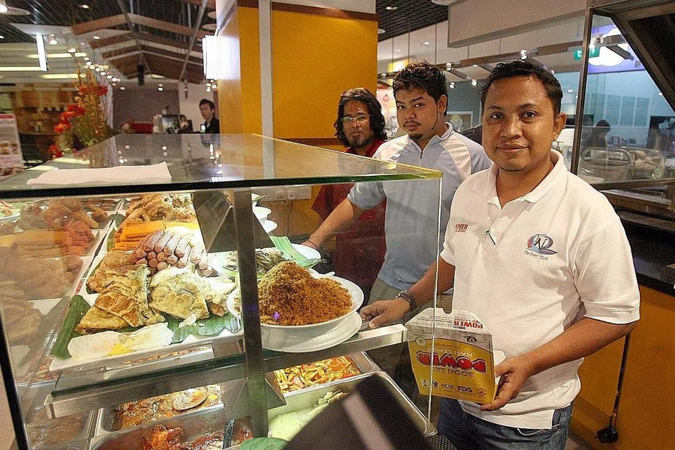 NASI LEMAK LEBIH DIKENALI: Pemilik Boon Lay Power Nasi Lemak, Encik Badrol Hisam Ramli (kanan), berkata langkah McDonald's memperkenal Burger Nasi Lemak secara tidak langsung memperkenal hidangan nasi lemak kepada pelancong dan anak muda yang melihat nasi lemak hanya sebagai makanan tradisional Melayu.