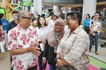 Menteri Pembangunan Sosial dan Keluarga, Encik Masagos Zulkifli Masagos Mohamad (kiri, barisan hadapan), berkongsi pandangan bersama Cik Yuzil Mohd Yusoff (kanan, barisan hadapan) semasa pelancaran Festival Sukarelawan (VFest) di Our Tampines Hub (OTH) pada 7 Julai.