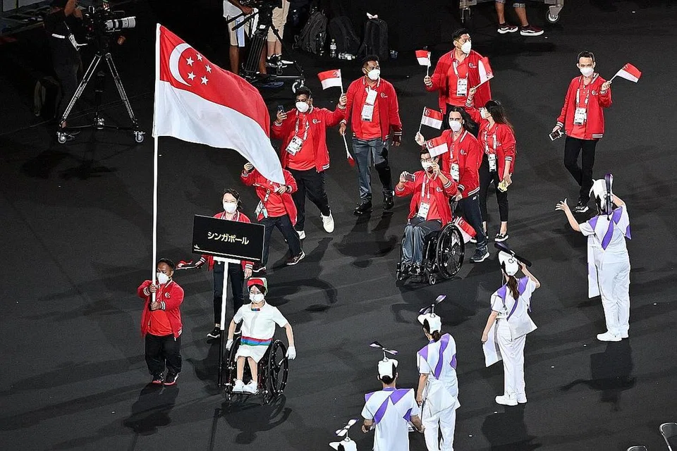 BERI PENGHARGAAN: (Gambar atas) Team Singapura tiba di upacara pembukaan untuk Sukan Paralimpik Tokyo 2020 di Stadium Olimpik di Tokyo pada 24 Ogos 2021. - Foto AFP