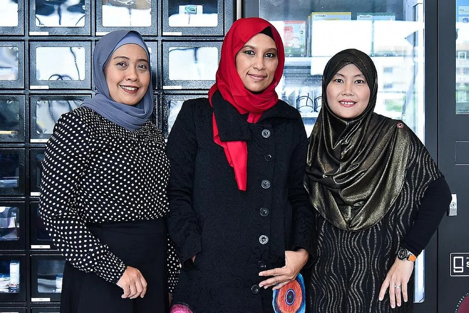 PELBAGAIKAN SALURAN PENJUALAN: Cik Aida Amanda Atan (tengah) menyediakan wadah mesin layan diri bagi peniaga seperti Cik Masturah Saadon (paling kiri) dan Cik Adilah Latip. - Foto BM oleh SONG TAO 