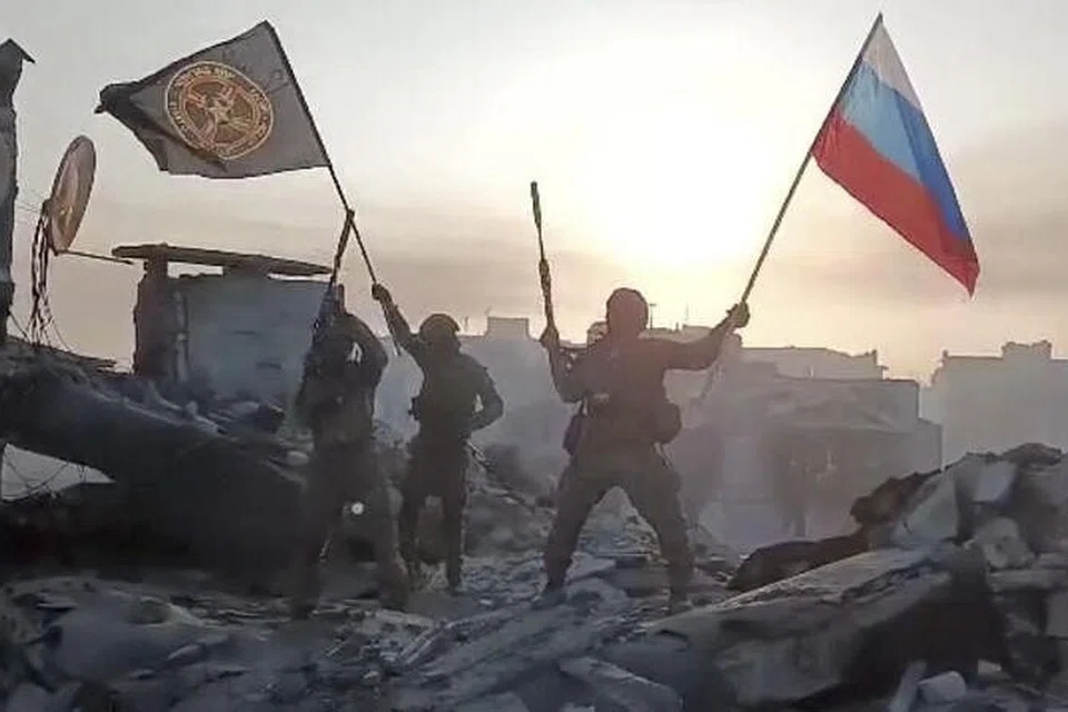 BERAKHIRNYA PERTEMPURAN?: Askar upahan Kumpulan Wagner mengibarkan bendera Russia dan bendera  Wagner di atas bumbung bangunan di Bakhmut, Ukraine. 