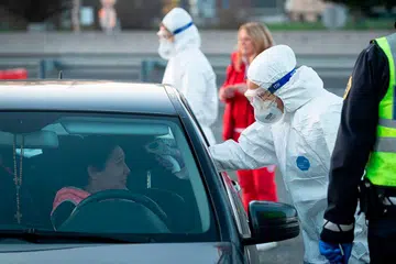 LANGKAH PENCEGAHAN: Seorang kakitangan perubatan mengambil suhu badan pemandu di sempadan Slovenia-Italy berdekatan Nova Gorica, kelmarin selepas pemerintah Slovenia mengumumkan ia akan menutup sempadan dengan Italy. - Foto AFP