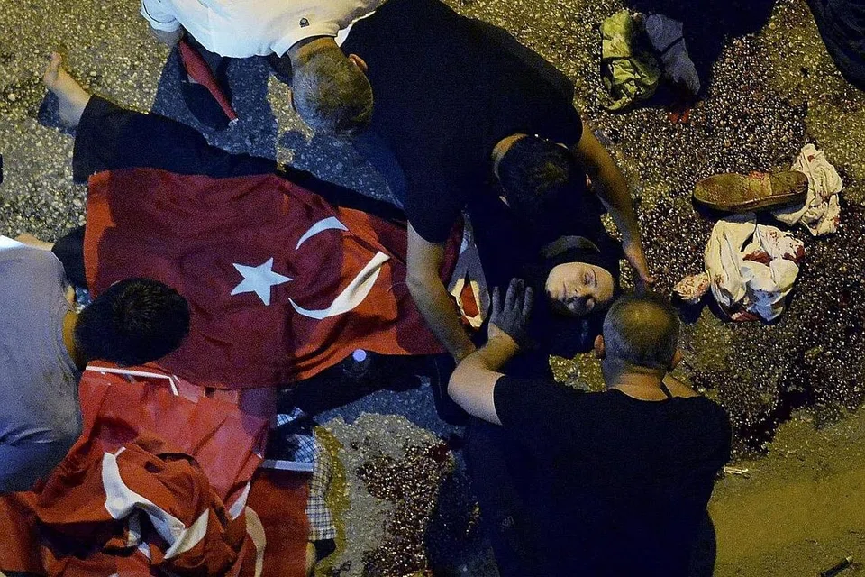 LEBIH 1,400 DILAPOR CEDERA: Seorang wanita yang tercedera dalam kejadian percubaan rampasan kuasa di Turkey diselimut dengan bendera negara itu dekat ibu pejabat tentera di Ankara, Turkey, Sabtu lalu. - Foto REUTERS