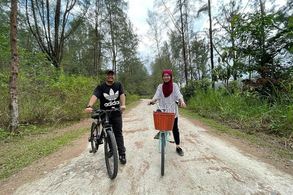 DIKELILINGI KEHIJAUAN: Wartawan Fakhruradzi Ismail dan Siti Aisyah Nordin berbasikal di Pulau Coney atau dikenali juga sebagai Pulau Serangoon, dikelilingi pelbagai jenis flora dan fauna. - Foto BH oleh ZULAIQAH ABDUL RAHIM